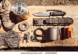 stock-photo-overhead-top-view-of-hiking-travel-gear-on-wood-log-items-include-hiking-boots-cup-rope-knife-420688960